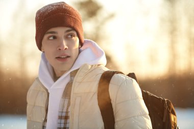 Yaşam tarzı. Parkta duran kışlık elbiseli yakışıklı bir adamın portresi. Mutlu insanlar konsepti.