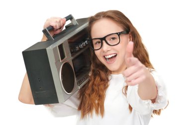 Beyaz bluzlu, uzun dalgalı saçlı, gözlüklü ve elinde müzik seti olan güzel mutlu bir genç kız fotoğrafı. Beyaz stüdyo geçmişi. Müzik.