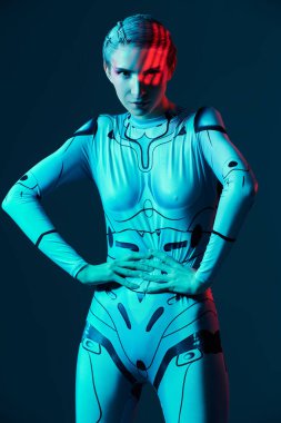 Gelecekçi uzay tarzı. Sanal siber uzay. Teknoloji tulumlu güzel bir siber punk kızı neon mavi ışıkta duruyor..
