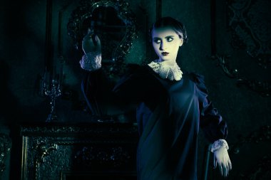 Kasvetli bir kalede ay ışığında dans eden, koyu siyah elbiseli, beyaz yakalı esmer gizemli bir kız. Mistik gotik roman. Addams Aile Stili.