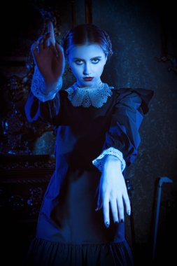 Kasvetli bir kalede ay ışığında dans eden, koyu siyah elbiseli, beyaz yakalı esmer gizemli bir kız. Mistik gotik roman. Addams Aile Stili.