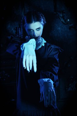 Kasvetli bir kalede ay ışığında dans eden, katı siyah elbiseli, beyaz yakalı çekici bir esmer kızın portresi. Mistik gotik roman. Addams Aile Stili.