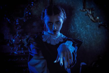 Kasvetli bir şatoda ay ışığında dans eden, katı siyah elbiseli, beyaz yakalı çekici bir esmer kız. Mistik gotik roman. Addams Aile Stili.