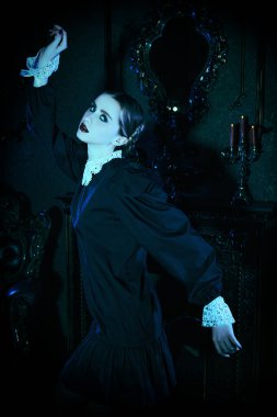 Kasvetli bir kalede ay ışığında dans eden, koyu siyah elbiseli, beyaz yakalı esmer gizemli bir kız. Mistik gotik roman. Addams Aile Stili.