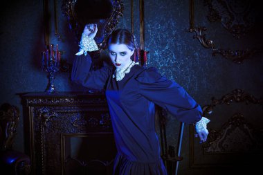 Kasvetli bir kalede ay ışığında dans eden, koyu siyah elbiseli, beyaz yakalı esmer gizemli bir kız. Mistik gotik roman. Addams Aile Stili.