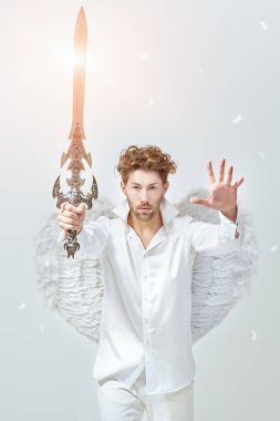 Görkemli Başmelek, önünde bir kılıçla nöbet tutuyor. Cennetin ışığıyla beyaz arka plan. Fantezi kahramanı. Sevgililer Günü.