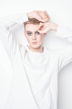 Güzel atış. Yakışıklı, şehvetli bir genç adamın portresi. Sarı saçlı, siyah dumanlı gözlü, beyaz duvarda poz veren bir manken. Makyaj ve saç stili. 