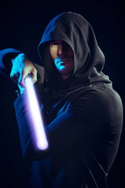 Bilim kurgu romanı. Siyah cüppeli, kapüşonlu cesur bir savaşçı karanlık bir arka planda lazer kılıcı tutuyor. Uzay fantezisi. 