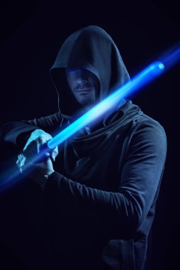 Bilim kurgu romanı. Siyah cüppeli, kapüşonlu cesur bir savaşçı karanlık bir arka planda lazer kılıcı tutuyor. Uzay fantezisi. 