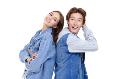 Denim tarzı, gençlik tarzı. Beyaz bir arka planda poz veren şık kot elbiseli gülümseyen genç erkek ve kız portresi..