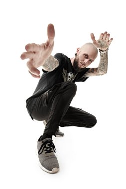 Punk rock müziği. Gayri resmi görünüşlü, kafası kazınmış, dudağında ve kulaklarında piercing olan, vücudunda dövmesi olan bir adam stüdyoda siyah giysiler içinde poz veriyor. Beyaz stüdyo geçmişi.