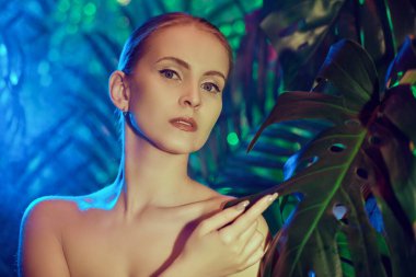 Güzellik, Spa. Tropik tatil. Tropikal bitkilerin arasında güzel bir genç kadının yakın plan portresi. Doğal organik kozmetik. Sağlık hizmetleri. 