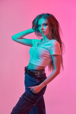 Güzellik, makyaj malzemesi ve saç stili. Esmer, dumanlı gözleri ve pembe arka planda uzun taranmış saçları olan çekici bir genç kız. Gençlik partisi bakışı.