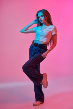 Moda ve tarz. Esmer, dumanlı gözleri ve pembe arka planda uzun taranmış saçları olan çekici bir genç kız. Gençlik partisi bakışı.