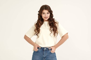 Kadın güzelliği. İnsanlar, mutlu duygular. Uzun kıvırcık saçlı, mutlu ve heyecanlı bir şekilde gülümseyen güzel bir kızın portresi. Kopyalama alanı olan beyaz stüdyo arkaplanı.