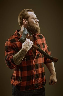 Berber dükkanı reklamı. Baltayla tıraş olan, ekose gömlekli, vahşi sakallı bir adamın portresi. Koyu gri stüdyo geçmişi. Erkek güzelliği ve erkeklik.