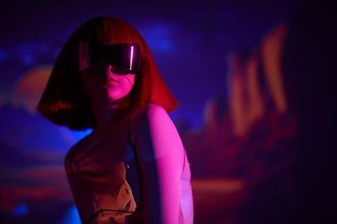 Fütürist bir kız, parlak kırmızı makyajlı ve şık kızıl saçlı, beyaz teknoloji kıyafetleriyle sanal gerçeklikte poz veriyor. Gelecekteki siber dünyanın konsepti. VR oyunları.