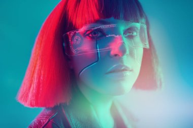 Oyun, sanal gerçeklik. Çekici bir siber punk kızı karışık ışıkta mavi bir arka plana karşı poz veriyor. Bilim kurgu cyborg kızı..