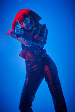 Geleceğin dijital teknolojileri. Fütürist gözlüklü, neon renkli ışıkta duran mükemmel siber kız. Siber uzay. Sanal gerçeklik oyunları.