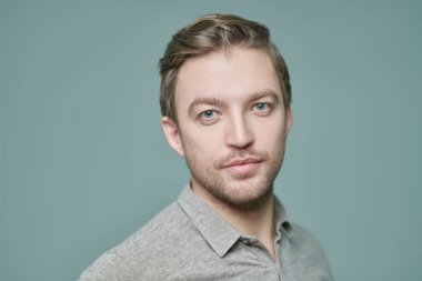 Kameraya bakan orta yaşlı bir adamın portresi. İnsanlar, duygular. Erkek sağlığı ve güzelliği. Gri arkaplanda stüdyo portresi. 