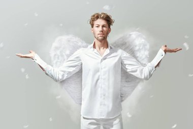 Aşk Tanrısı Aşk Tanrısı. Beyaz elbiseli ve beyaz kanatlı cesur, yakışıklı bir aşk meleği. Beyaz arka plan. Sevgililer Günü.