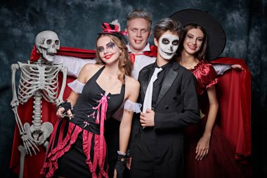 İskelet, cadı, palyaço ve vampir. Mutlu Cadılar Bayramı Partisi. Karnaval kostümlü genç bir arkadaşın portresi Cadılar Bayramı 'nı kutlarken eğleniyor. Stüdyo resmi.