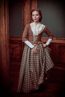 18. yüzyıldan kalma İskoç elbiseli güzel bir aristokrat kızın klasik iç mimarisi olan bir odada dikilirken tam boy fotoğrafı. Romanın kadın kahramanı. 18. yüzyıl tarzı.