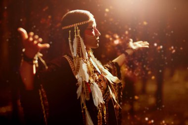 Amerikalı bir Hintli şaman kadın şafak vakti ormanda dururken doğanın ruhlarıyla iletişim kuruyor. Amerika 'nın tarihi ve etnik kültürü.