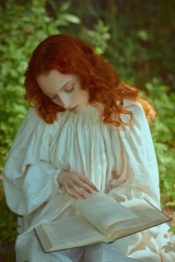 Beyaz bir gecelik giymiş, parlak kırmızı dalgalı saçlı güzel bir kız çayırdaki çimlere oturur ve bir kitap okur. Romanın kadın kahramanı. Romantizm çağı, 18-19 yüzyıl..
