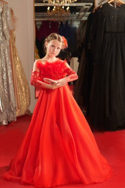 Kırmızı Halı 'daki küçük hanım. Çocuklar yüksek moda. Kırmızı halıda gece elbisesi içinde şık kırmızı bir gece elbisesiyle poz veren güzel bir manken. Lüks stil.