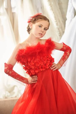 Lüks akşam tarzı. Çocukların tatil modası. Gece elbisesinde uzun kırmızı bir parti elbisesi içinde poz veren güzel bir kız modelin portresi..