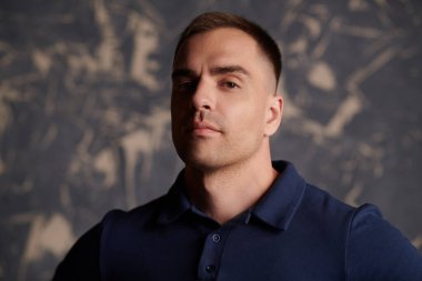 Stüdyoda poz veren atletik yapılı yakışıklı erkek portresi. Erkek güzelliği ve sağlığı. Spor yaşam tarzı..