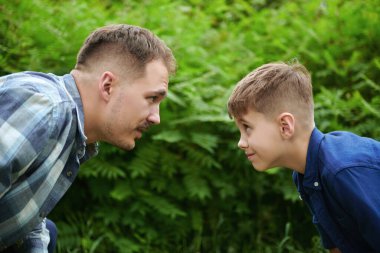 Baba oğul bir yaz parkında oynuyorlar. Mutlu bir aile. Yaz zamanı ve tatil.