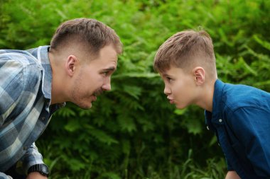 Baba oğul bir yaz parkında oynuyorlar. Mutlu bir aile. Yaz zamanı ve tatil.