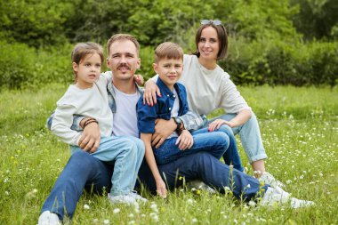 Neşeli, dost canlısı bir aile ailesi ve iki çocuğu yaz parkında dinleniyor. Yaz zamanı ve tatiller. Mutlu bir aile.. 