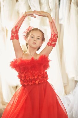 Lüks akşam tarzı. Gece elbisesinde uzun kırmızı bir parti elbisesi içinde poz veren güzel bir kız modelin portresi. Çocukların tatil modası. 