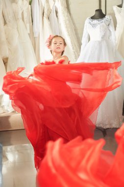 Gece elbisesinde uzun kırmızı bir parti elbisesi içinde poz veren güzel bir kız modelin portresi. Lüks akşam tarzı. Çocukların tatil modası. 