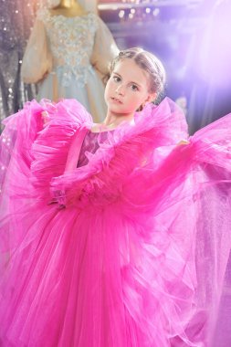 Gece elbisesi içinde lüks bir fuşya elbisesi içinde poz veren güzel bir kadının portresi. Akşam saç stili. Kızlar için akşam modası.