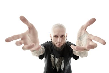 Tıraş olmuş, siyah bir papaz gömleği giymiş zalim bir adam yumruklarını dövmeyle gösteriyor. Antisosyal davranış, protesto ifadesi. Beyaz stüdyo geçmişi.