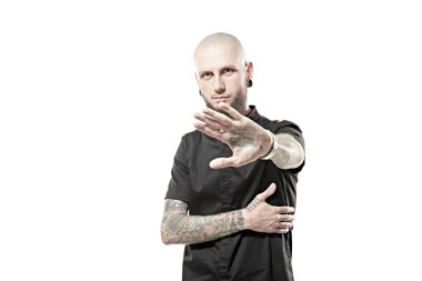 Protesto ifadesi. Antisosyal davranış. Tıraş olmuş, siyah bir papaz gömleği giymiş zalim bir adam yumruklarını dövmeyle gösteriyor. Beyaz stüdyo geçmişi. Metin için boşluk.