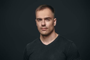 İnsanlar ve duygular. Atletik yapılı, yakışıklı, güçlü bir adamın portresi. Metin için alanı olan siyah arkaplan. Aktif, sağlıklı bir yaşam tarzı. Spor..