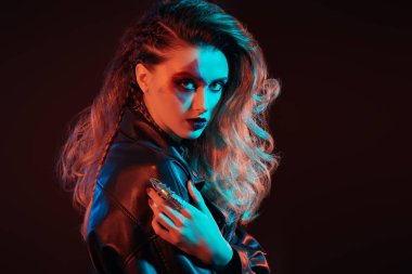 Pop ve Rock müzik. Parlak parlak makyajlı ve parlak rock tarzı renkli sahne ışıklarıyla saçı olan bir rock yıldızının yakın çekimi. Kaya aksesuarlar. Metin için yer.