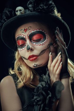 Siyah arka planda Calavera Atrina makyajı olan güzel ve korkutucu bir kızın portresi. Ölüler Günü 'nün sembolü. Cadılar Bayramı. Dia de los Muertos. 