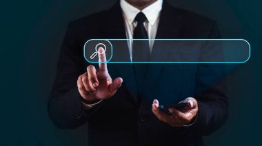 İşadamı akıllı telefon kullanıyor ve koyu mavi arka planda arama çubuğuna dokunuyor.