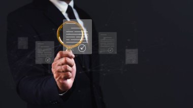 İş adamı koyu arkaplana karşı sanal ekran belge yönetimi ile büyüteç kullanıyor.