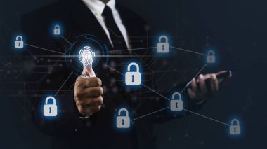 İşadamı karanlık arka plana karşı akıllı telefon kullanırken verileri açmak için başparmağını kaldırıyor.