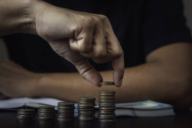 Bir adam bozuk paraları en aşağıdan en yükseğe sıralıyor..