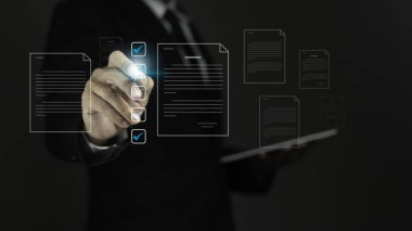 Tablet kullanan ve görsel ekrandaki analiz verilerini kontrol eden işadamı. 