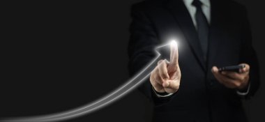 İşadamı bir cep telefonu kullanıyor ve şirketin iş ve mali büyümesini gösteren oklar çiziyor.