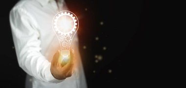 Bir adam içinde vites şeklinde bir ampul tutar..